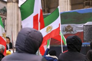 Demonstrierende Menschen mit Protestplakaten, die für Menschenrechte im Iran eintreten.
