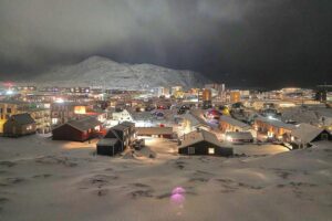 Bild von Nuuk: malerische Stadt, grüne Landschaft, fjordartige Küste, klare Sicht auf Berge.