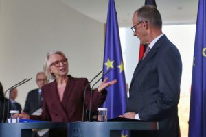 Monika Schnitzer und Friedrich Merz diskutieren über US-Zölle und europäische Wirtschaftsstrategien.
