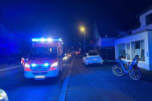 Radfahrerin prallt gegen geöffnete Autotür; Unfallstelle zeigt verletzte Frau und Pedelec.
