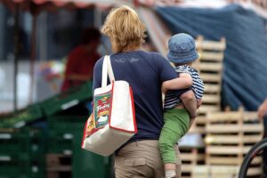 Frau mit Kind symbolisiert Herausforderungen der Teilzeitarbeit und Familienbetreuung in Deutschland.