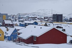 Nuuk, Grönland: Wunderschöne Stadtansicht mit schneebedeckten Bergen und bunten Häusern am Wasser.
