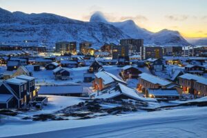 Eine beeindruckende Landschaft von Nuuk, Grönland, mit schneebedeckten Bergen und bunten Häusern.