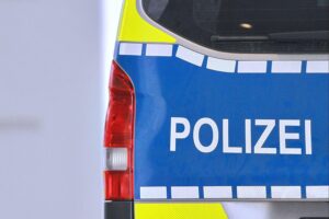 Polizei vor einem beschädigten Geschäftsgebäude nach Schüssen in Ludwigsburg, mit Einsatzfahrzeugen.