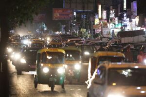 VW- und Mercedes-Chefs diskutieren Handelsabkommen in lebhafter Neu-Delhi-Straßenszene mit Autos.