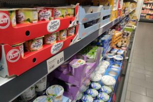 Joghurt im Supermarktregal, symbolisiert Lebensmittelpreise und Verbraucherinteressen beim "Deutschlandkorb".