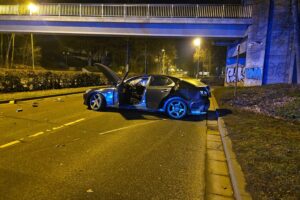 Ein verunfalltes Auto blockiert die Straße, Feuerwehr und Rettungsdienst sind im Einsatz.