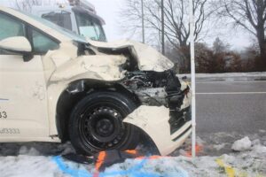 Unfallaufnahme: beschädigtes Taxi, Rettungswagen, Polizei, verletzte Personen, Verkehrschaos auf Landstraße.