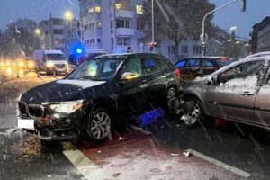 Unfallstelle in Mönchengladbach mit zwei beschädigten Autos und Polizei vor Ort.