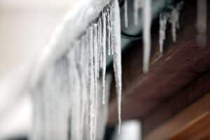 Eiszapfen an einer Regenrinne, symbolisierend winterliches Wetter und Schneefall in Nordrhein-Westfalen.