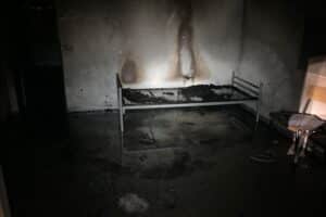 Brandwohnung mit Feuerwehr im Einsatz, Einsatzkräfte löschen Glutnester, keine Verletzten, Nachtaufnahme.