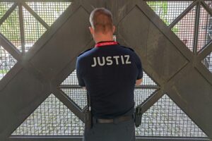 Ein Wachmeister schließt das Gefängnistor, symbolisch für Justiz und Sicherheit in Pforzheim.