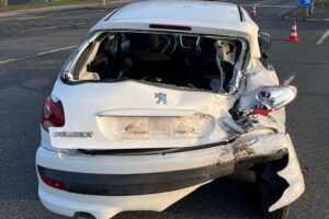 Zwei verunfallte Autos an einer Straßenecke, Polizei vor Ort, Unfallaufnahme im Gange.