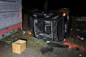 Verunfallter Smart liegt auf der Seite; Polizei untersucht winterlichen Straßenunfall.