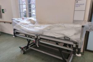 Krankenhausbett in kritischer Diskussion über Militarisierung des Gesundheitswesens im Brandenburger Landtag.