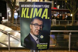 Grünes Wahlplakat zur Landtagswahl in Baden-Württemberg mit Umfrageergebnissen und aktuellen Parteienpräferenzen.