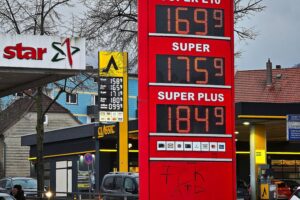 Tankstelle mit Preisschildern für Benzin und Diesel, Preiserhöhung für Benzin, Preissenkung für Diesel.