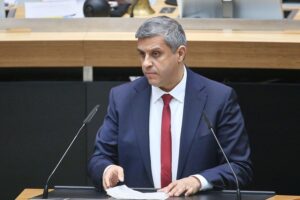 Raed Saleh, SPD-Politiker, diskutiert über Berlins neues Kleingartengesetz. Grüne Parzellen im Hintergrund.