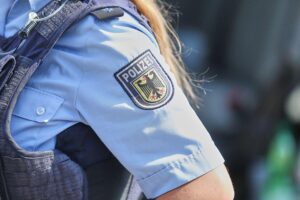 Polizisten kontrollieren Reisende an Bahnhof; Festnahmen wegen Haftbefehlen und Gesetzesverstößen.