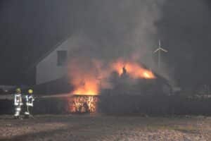Brand eines Carports in Lemwerder, Feuerwehr im Einsatz, angrenzendes Wohnhaus bedroht.
