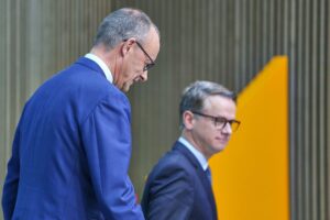 Friedrich Merz und Carsten Linnemann lächeln, symbolisieren politische Stabilität und Zukunftsperspektiven der CDU.