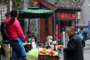 Markt in Peking mit Ständen, Menschen und bunten Waren, Symbol für bilateralen Handel und Zusammenarbeit.