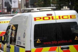 Peter Mandelson wird von Zivilbeamten in London festgenommen, umgeben von Polizeiautos.
