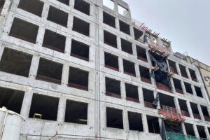 Baustelle mit Wohnungsbau, Baugenehmigungen und Handwerkern, Symbol für steigende Bauaktivität in Deutschland.