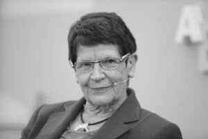 Eine Kerze in Gedenken an Rita Süssmuth, umgeben von Blumen und einer Trauerflor.