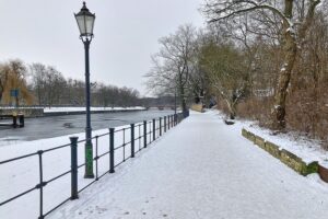 Schneebedeckte Straße in Berlin mit sichtbaren Gefahren durch Eis und versagenden Winterdienst.