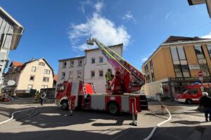 Feuerwehrdrehleiter kontrolliert Dach eines leerstehenden Hauses nach Ofendefekt, Rauch und Brandgeruch.