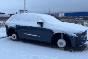 PKW ohne Felgen auf Backsteinen, Diebstahl im Autohaus. Polizei sucht Zeugen.