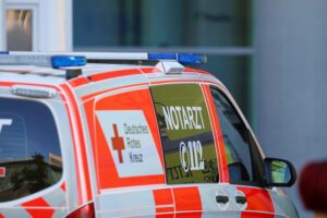 Notarzt an Unfallstelle, beschädigte Autos, Rettungsdienst und Feuerwehr im Einsatz.