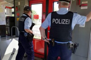 Polizisten patrouillieren in einem Zug, Sicherheitsdebatte bei der Deutschen Bahn im Fokus.