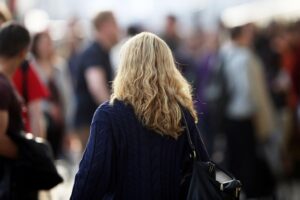 Blonde Frau mit Locken symbolisiert die Gender-Diskussion im Arbeitsmarktvergleich zwischen Berlin und Brandenburg.