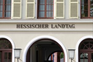 Hessischer Landtag mit Bild von Boris Rhein und Finanzminister Alexander Lorz während einer Pressekonferenz.