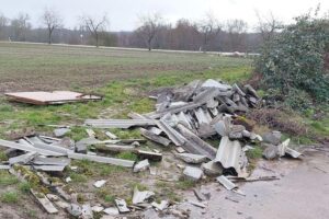 Illegaler Bauschutt auf einem Feldweg, Polizeiuntersuchung wegen Umweltstraftat.