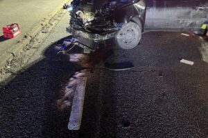 Ein VW Lupo prallt gegen Container; Unfallstelle mit Polizei und beschädigtem Fahrzeug.