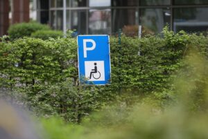 Eine barrierefreie Umgebung mit einem Behinderten-Parkplatz und Menschen, die Unterstützung erhalten.