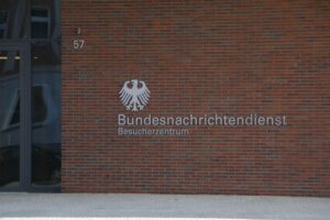 Bild von Thorsten Frei, BND-Logo und Sicherheitskonzepten zur Stärkung deutscher Geheimdienstbefugnisse.