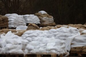 Sandsäcke für den Hochwasserschutz, symbolisieren den neuen Pakt für Sicherheit und Naturschutz.