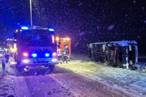 Lkw-Unfall: Umgestürzter Lastwagen im Graben, Feuerwehr im Einsatz, Person gerettet.