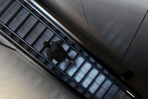 Mann nutzt Rolltreppe; Probleme mit Rolltreppen an deutschen Bahnhöfen betont Mobilitätsherausforderungen.