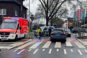 Unfallstelle mit Radfahrerüberfahrt, Polizei vor Ort, betroffene Radfahrerin im Krankenhaus.