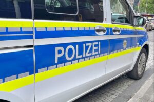 Unfallstelle mit Polizei, Radfahrer und Pkw, möglicherweise schwer verletzte Frau, Spurensicherung aktiv.