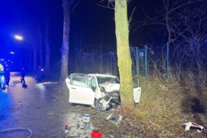 Schwerer Verkehrsunfall mit deformiertem Auto, Feuerwehr und Rettungsdienst im Einsatz.