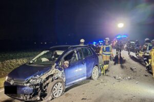 Zwei Unfallautos, Einsatzkräfte der Feuerwehr und Absperrungen auf Grevens Altenberger Straße.