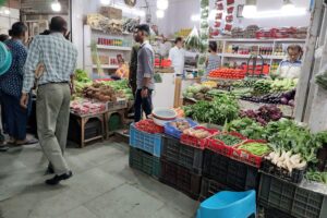 Markt in Neu-Delhi mit leuchtenden Ständen und geschäftigen Menschen, symbolisiert Indien und Handel.