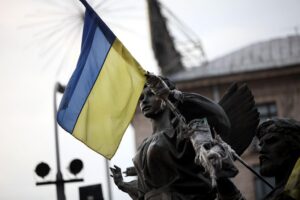 Ukrainische Flagge vor blauem Hintergrund, symbolisiert Verhandlungen und Frieden zwischen Ukraine und Russland.
