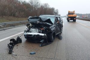 Verunfallte Fahrzeuge blockieren Autobahn, während Einsatzkräfte die Unfallstelle sichern und bereinigen.